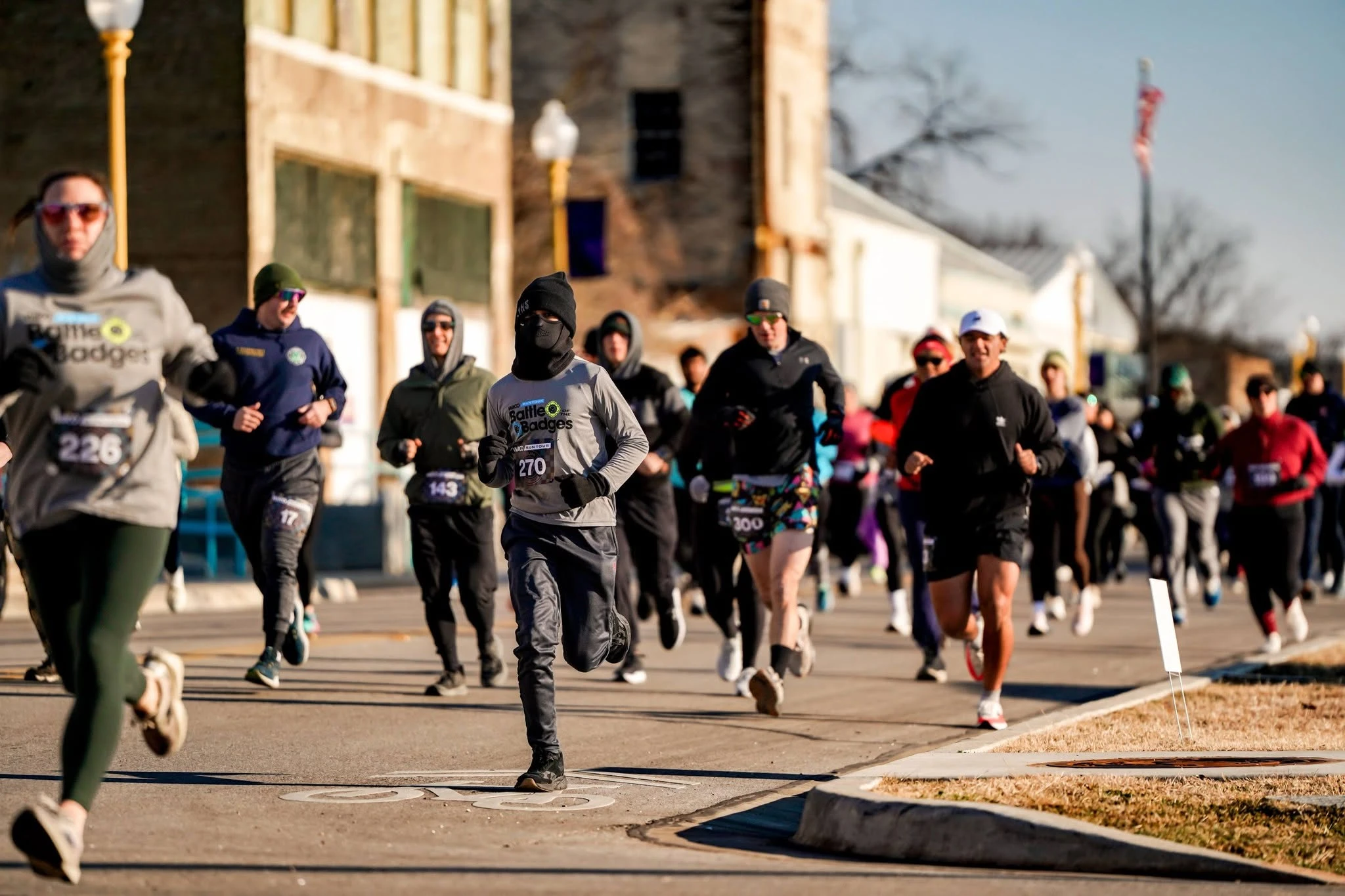 Runners wearing Waco Run Tour race bibs on a downtown street
